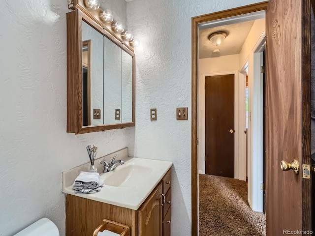 380 S 25th Ave, Brighton, CO 80601 - half bath featuring vanity, a textured wall, and toilet