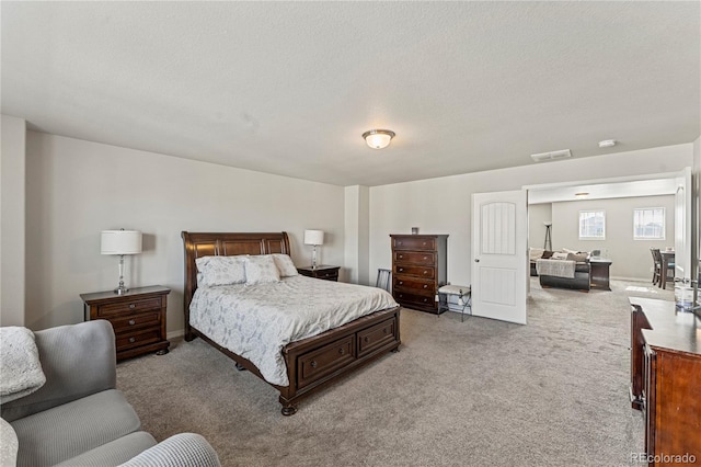 bedroom with a textured ceiling, baseboards, visible vents, and carpet floors