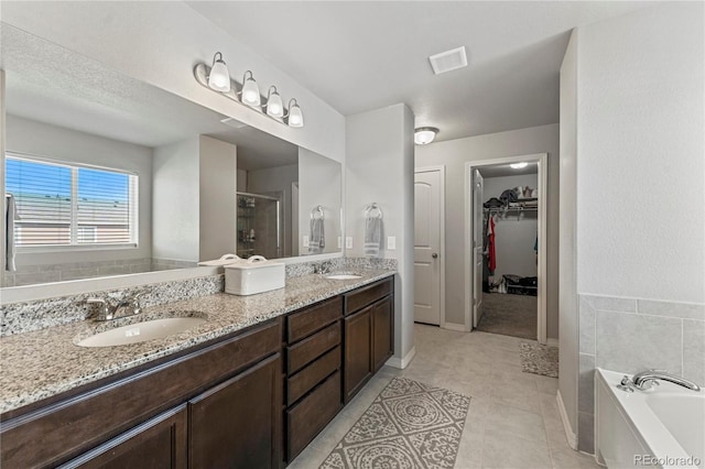 full bath featuring a shower stall, a garden tub, double vanity, and a sink