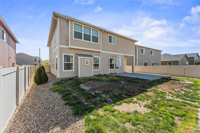 rear view of property with a patio and a fenced backyard