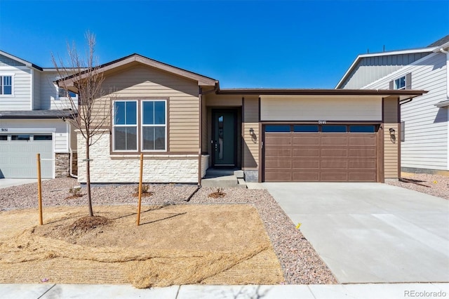 view of front of home with stone siding, concrete driveway, and a garage