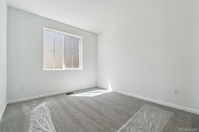 carpeted empty room with baseboards and visible vents