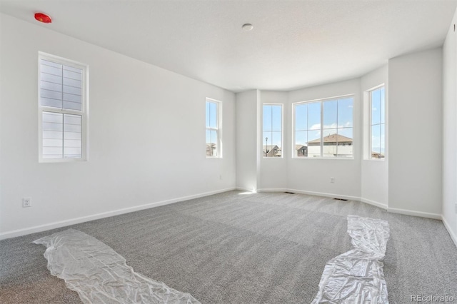 empty room featuring carpet floors and baseboards
