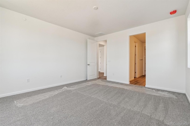 unfurnished room with baseboards and carpet flooring