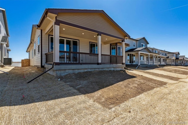 view of front of property with a residential view, central air condition unit, and covered porch