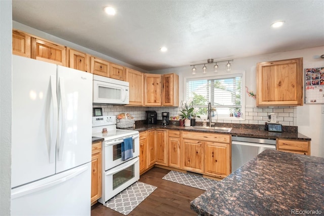 12296 Birch St, Thornton, CO 80241 - kitchen featuring white appliances, backsplash, dark wood-style floors, recessed lighting, and dark stone countertops