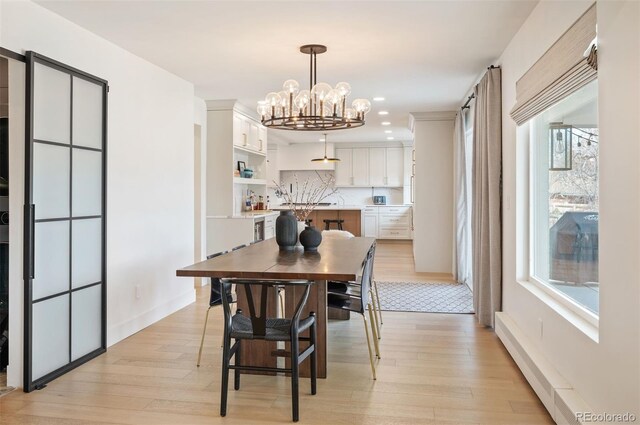 dining space with baseboards, recessed lighting, light wood-type flooring, and a notable chandelier