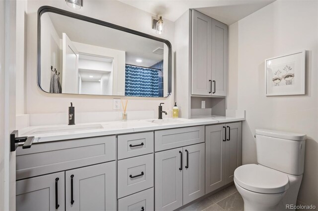 bathroom with tile patterned flooring, a sink, toilet, and double vanity