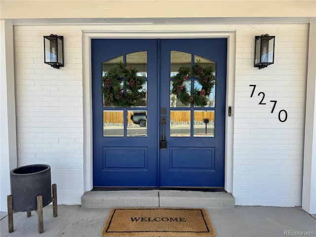 doorway to property featuring french doors and brick siding