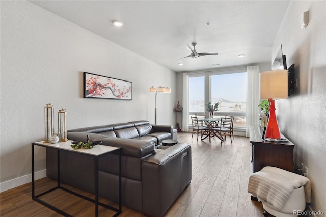 living room featuring hardwood / wood-style floors and ceiling fan