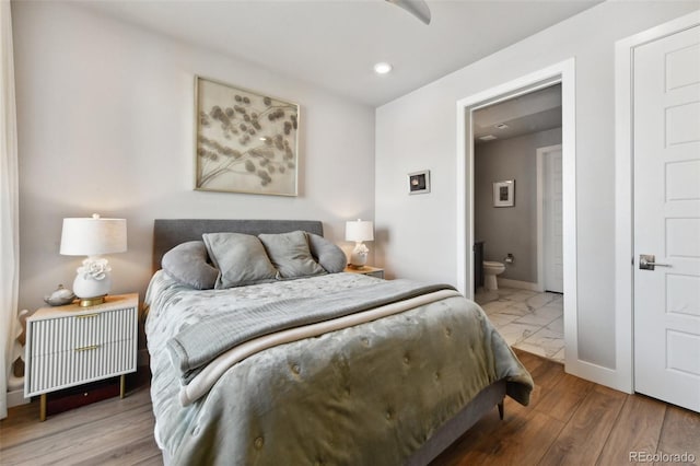 bedroom with hardwood / wood-style flooring and ensuite bath