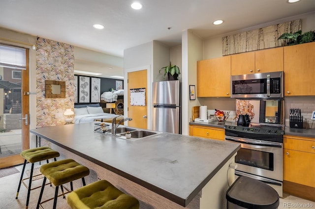 801 Confidence Dr Unit 2, Longmont, CO 80504 - kitchen with stainless steel appliances, a sink, recessed lighting, dark countertops, and a breakfast bar
