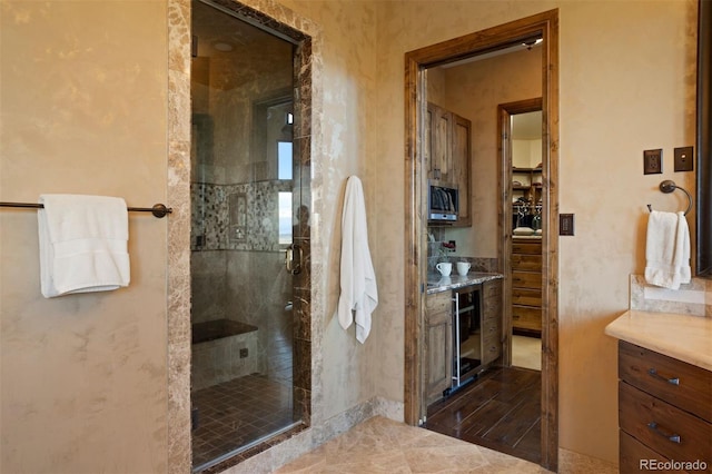 bathroom featuring wine cooler and an enclosed shower