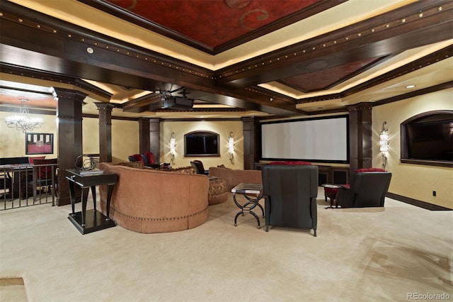 home theater room featuring ornate columns, light carpet, ceiling fan with notable chandelier, and ornamental molding