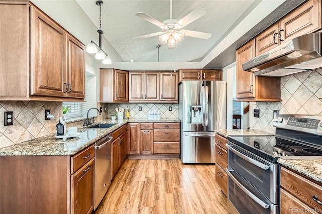 6367 Xavier St, Arvada, CO 80003 - kitchen featuring stainless steel appliances, under cabinet range hood, a sink, backsplash, and vaulted ceiling