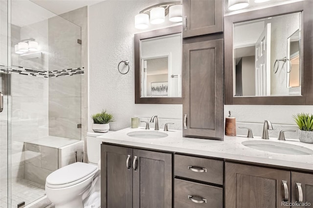 6367 Xavier St, Arvada, CO 80003 - bathroom featuring a textured wall, a shower stall, double vanity, and toilet