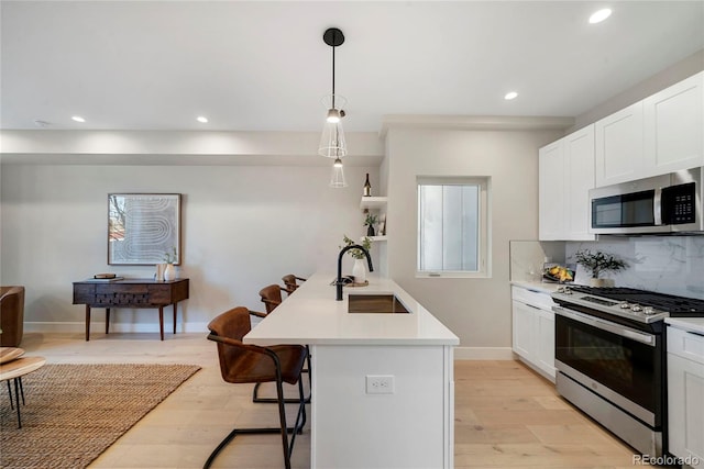 1473 N Locust, Denver, CO 80220 - kitchen featuring appliances with stainless steel finishes, a kitchen bar, recessed lighting, light countertops, and backsplash