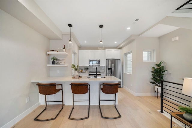 1473 N Locust, Denver, CO 80220 - kitchen featuring stainless steel appliances, a peninsula, open shelves, light countertops, and white cabinets