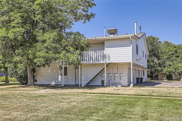 back of house featuring a yard and stairway