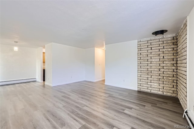 unfurnished room featuring brick wall, a baseboard radiator, and wood finished floors