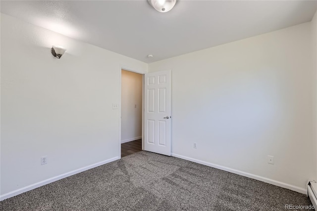 spare room featuring a baseboard radiator, carpet, and baseboards