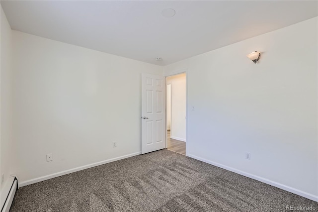 spare room with carpet, a baseboard heating unit, and baseboards