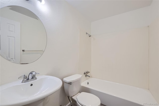 bathroom with washtub / shower combination, a sink, and toilet