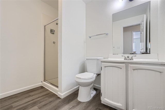 full bathroom with vanity, wood finished floors, a shower stall, and toilet