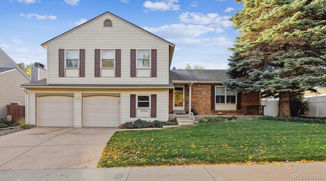 tri-level home featuring fence, driveway, an attached garage, a front lawn, and brick siding