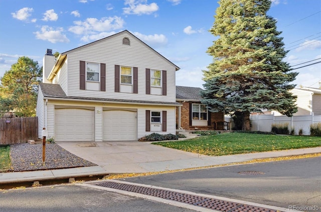 split level home featuring fence, concrete driveway, a front yard, a chimney, and a garage