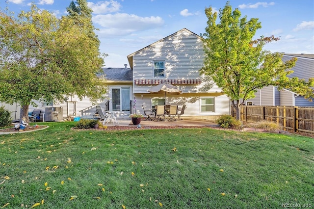 back of property with a patio area, a lawn, and fence