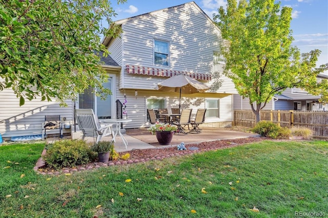 rear view of house with a yard, a patio, and fence