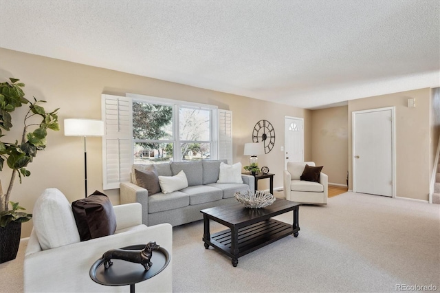 living room with baseboards, light carpet, and a textured ceiling