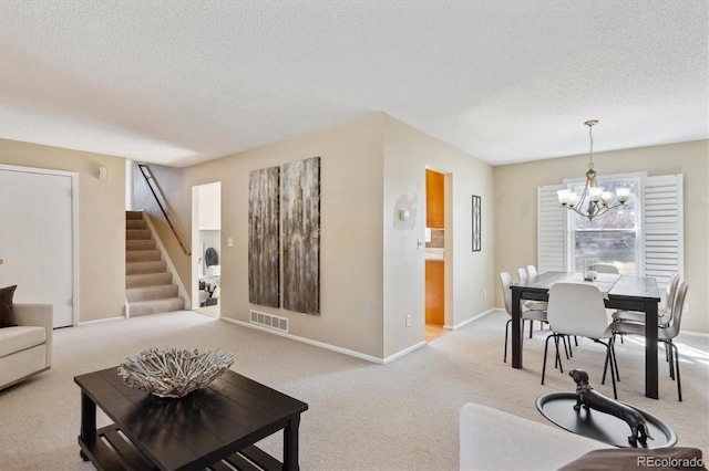 living room featuring visible vents, carpet floors, a chandelier, and stairs