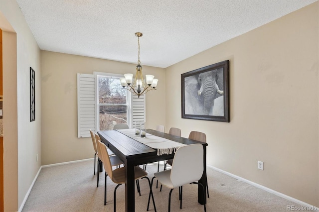 dining area featuring an inviting chandelier, light colored carpet, and baseboards