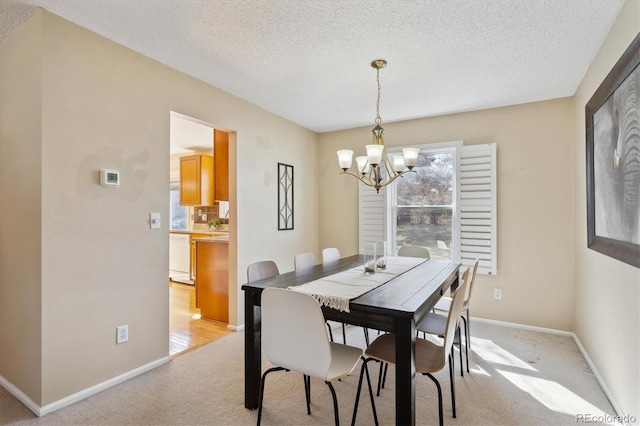 dining space with baseboards, light carpet, a notable chandelier, and a textured ceiling