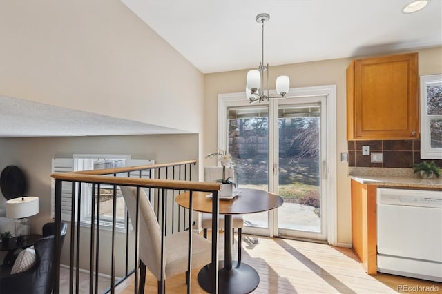 dining room with a notable chandelier, stairs, and light wood-type flooring