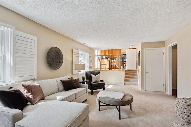 living room with light carpet, stairway, and a textured ceiling