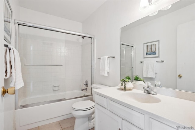 full bathroom with tile patterned floors, combined bath / shower with glass door, toilet, and vanity