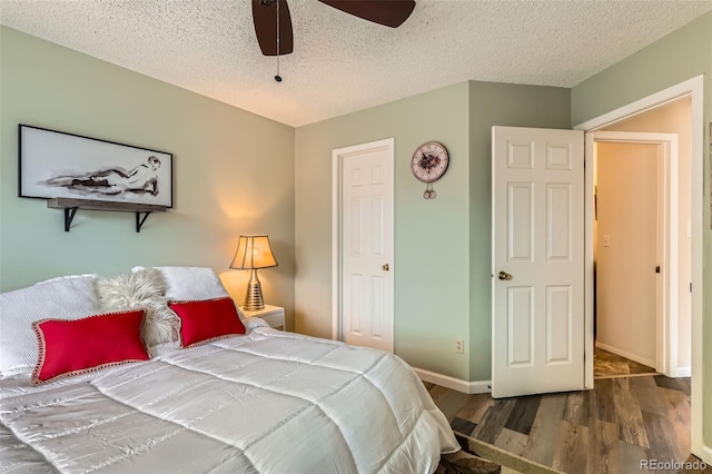 bedroom with ceiling fan, a textured ceiling, baseboards, and wood finished floors