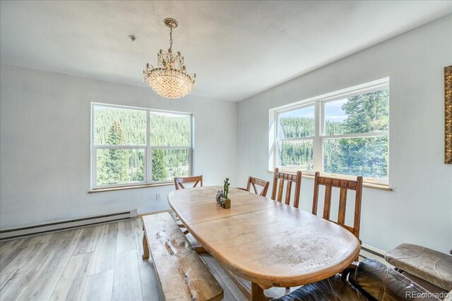 234 Carroll Ln, Breckenridge, CO 80424 - dining space with a chandelier, healthy amount of natural light, wood finished floors, and a baseboard heating unit