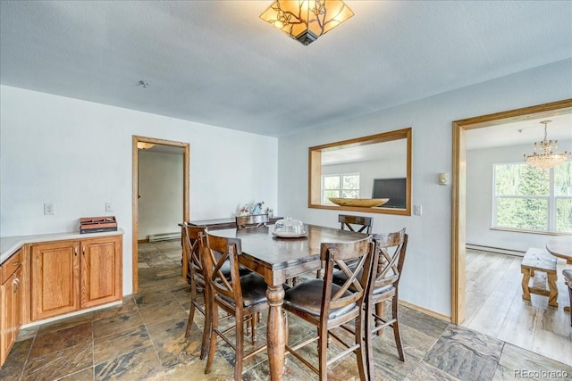 234 Carroll Ln, Breckenridge, CO 80424 - dining area with healthy amount of natural light, a baseboard radiator, a chandelier, and a textured ceiling