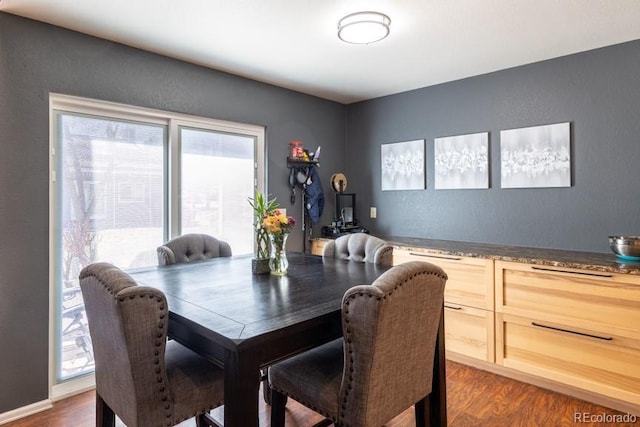 dining space with baseboards and wood finished floors