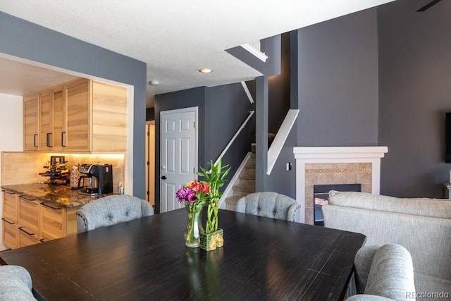 dining room featuring stairway, a tiled fireplace, and recessed lighting