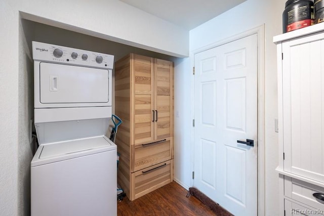 laundry area featuring dark wood-style floors, laundry area, and stacked washer and clothes dryer