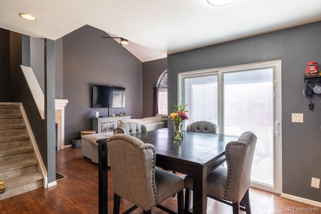 dining area with lofted ceiling, baseboards, stairway, and wood finished floors