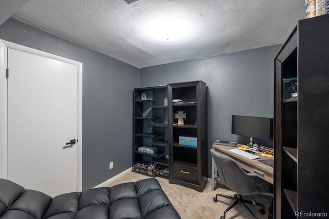 office featuring a textured ceiling, a textured wall, baseboards, and light colored carpet