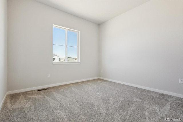 empty room with carpet flooring, baseboards, and visible vents