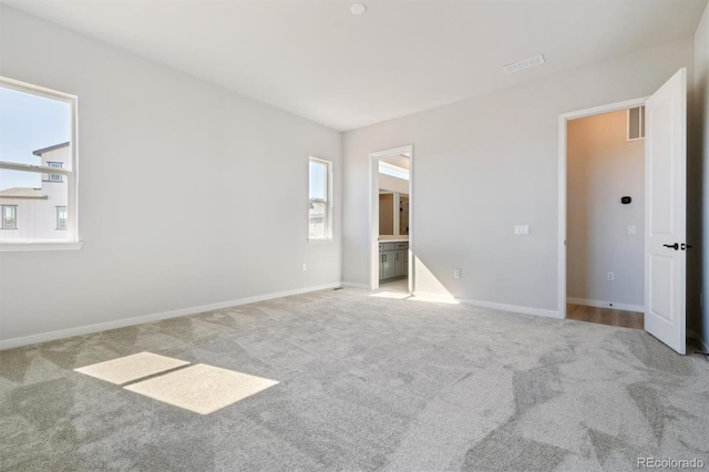 unfurnished bedroom with carpet flooring, baseboards, and visible vents