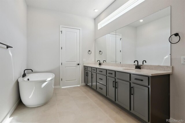 full bath featuring a sink, baseboards, a soaking tub, and double vanity